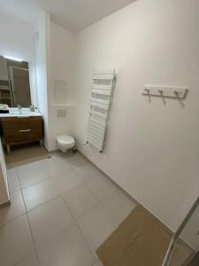 een witte badkamer met een toilet en een wastafel bij Appart charmant au cœur de la ville et des commodités in Saint-Ouen