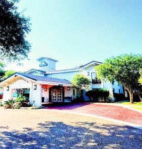 a large white building with a driveway in front of it at Days Inn by Wyndham Sulphur West in Sulphur