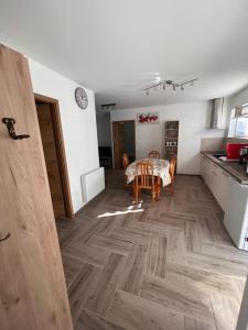 een keuken en eetkamer met een houten vloer bij Gîte chez Audrey et Pascal in Westhouse