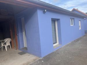 una pared azul de una casa con una mesa en Gîte chez Audrey et Pascal, en Westhouse
