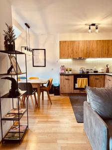 Una sala de estar con una mesa y una cocina. en Śnieżkowe Love - dwupoziomowy apartament z garażem, en Karpacz