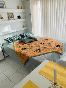 um quarto com uma cama com um cobertor laranja e almofadas em Studio Abee em Middelkerke