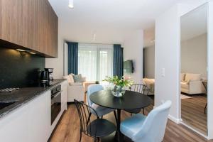 a kitchen and living room with a table and chairs at Scala Rentyear Apartments in Gdańsk