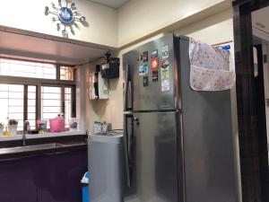 a kitchen with a stainless steel refrigerator and a sink at The Luxurious Haven-Lokhandwala in Mumbai