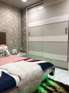 a bedroom with a bed with a large headboard at The Luxurious Haven-Lokhandwala in Mumbai