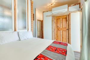 ein Schlafzimmer mit einem weißen Bett und einer Holztür in der Unterkunft La Colina El Prado Condo with Hot Tub, Deck and Views in El Prado