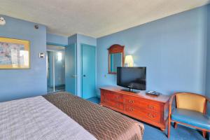 a bedroom with a bed and a television on a dresser at Enticing Ocean View Condo located on the blvd, wifi included, monthly winter ren in Myrtle Beach