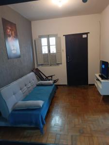 a living room with a blue couch and a television at Casa Do Roger Hospedagem in Ouro Preto