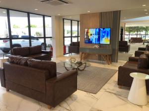 a living room with couches and a flat screen tv at Nobile Hotel Araripina in Araripina