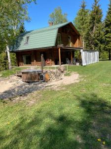 a log cabin with a hot tub in front of it at Kooli talu puhkemaja in Valingu