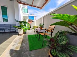 un patio con tavolo, sedie e piante di The Cozy Homestay a Kuah
