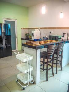 una cucina con bancone, sgabelli e piano di lavoro di The Cozy Homestay a Kuah