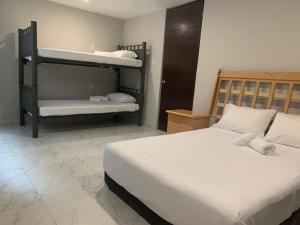 メキシコシティにあるHostal Boutique de Veneciaのベッドルーム1室(白いシーツが備わる二段ベッド2組付)