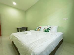 una camera da letto con un grande letto bianco con cuscini di The Cozy Homestay a Kuah