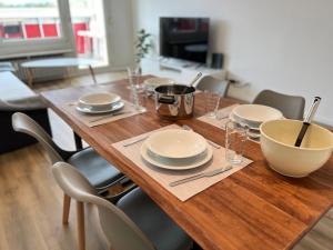 una mesa de madera con platos y cuencos en KEEP Hosting L24 Apartment, 