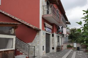 a red building with a balcony on a street at Casa Magini in Settecamini