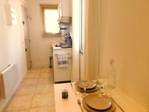 eine Küche mit einem Tisch mit Tellern und Gläsern darauf in der Unterkunft #2 Studio # Place charmante in Toulon