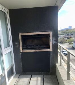 uma parede preta com um grelhador na varanda em Departamento en Ushuaia em Ushuaia
