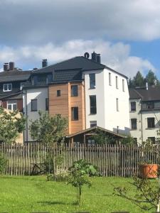 a large white house behind a wooden fence at Ferienwohnung Schöneck in Schöneck