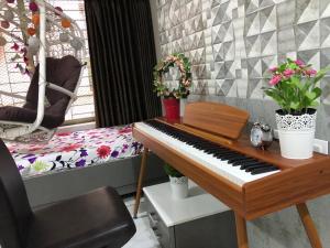 a piano in a room with a chair and flowers at The Luxurious Haven-Lokhandwala in Mumbai