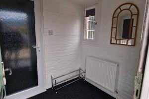 Cette chambre dispose d'une porte, d'une fenêtre et d'un miroir. dans l'établissement Luxury 3 Bed Detached House, à Farsley