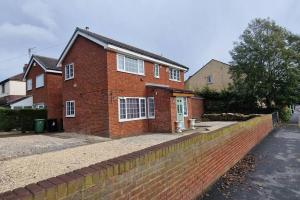 a red brick house with a brick wall at Luxury 3 Bed Detached House in Farsley