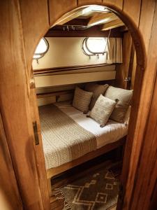 a small bed in an archway on a train at Wooden Boat- La Goletta in Barcelona