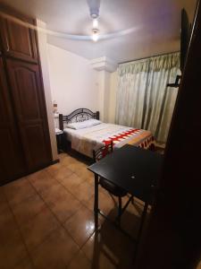 1 dormitorio con 1 cama y 1 mesa en una habitación en Hostal David Alejandro, en Quito
