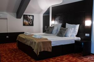 a bedroom with a large bed with white sheets and pillows at VILA COMO EN CASA - FREE PARKING in Sarajevo
