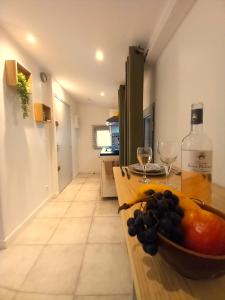 Una cocina con una mesa con un bol de fruta y copas de vino. en #3 Studio # Place charmante, en Toulon