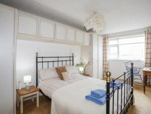 a bedroom with a large bed and a window at Wingelock in Rhosneigr