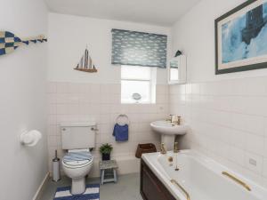a bathroom with a tub and a toilet and a sink at Wingelock in Rhosneigr +39 photos