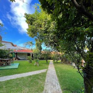 einen Garten mit einem Weg zum Haus in der Unterkunft Pousada Le Baron in Praia do Frances