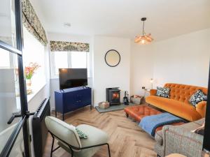 - un salon avec un canapé et une télévision dans l'établissement Park Cottage, à Carinish