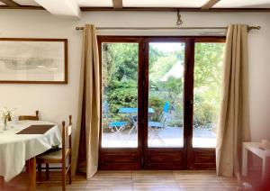 a dining room with a table and a glass door at Domaine de la Tranquillité V in Noyal-Muzillac
