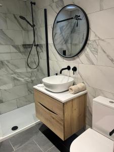 a bathroom with a sink and a mirror at The Curious Apartment, Cheltenham in Cheltenham