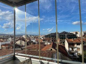 uma vista da cidade a partir de uma janela em Purple apartment- em Prizren