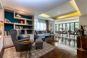 a living room with blue walls and a couch and chairs at Villa 88 Nimman-Chiang Mai in Chiang Mai