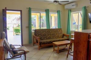 a living room with a couch and some windows at Casa Palma Placencia in Placencia Village