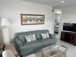 uma sala de estar com um sofá e uma televisão de ecrã plano em Villa 6 - Aloha Kai Vacation Villas em Siesta Key