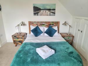 a bedroom with a bed with a green blanket and two lamps at Stylish 2-bed Flat, Quick Access to London Sights in London