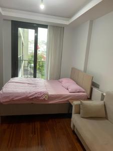 een slaapkamer met een bed, een bank en een raam bij Studio Flat-One Room in lux residence near Taksim-Beyoglu in Istanbul