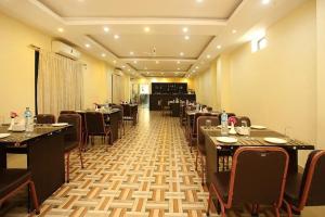 Hotel Castle في بهيراهاوا: مطعم فيه طاولات وكراسي في الغرفة