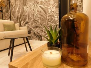 a candle and a bottle on a table in a living room at #3 Studio # Place charmante in Toulon