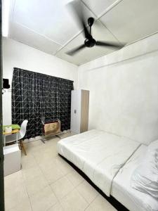 Homestay Eco Rengas Jaya في Padang Rengas: غرفة نوم بسرير ومروحة سقف