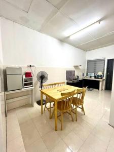 cocina con mesa y sillas en una habitación en Homestay Eco Rengas Jaya, en Padang Rengas
