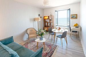 een woonkamer met een bank en een tafel bij La BALEINE BLEUE in Saint-Aubin-sur-Mer