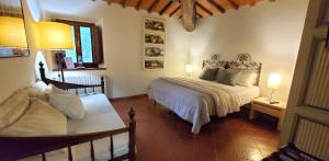 een slaapkamer met een bed en een bank erin bij La Volpaia 1521 in Barberino di Val dʼElsa