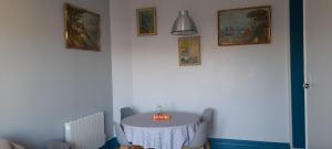 einen Tisch in einem Zimmer mit Gemälden an der Wand in der Unterkunft Au bon air in Wimereux