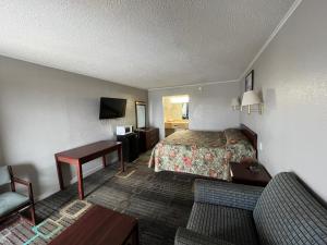 um quarto de hotel com uma cama e um sofá em Hotel 81 El Reno em El Reno